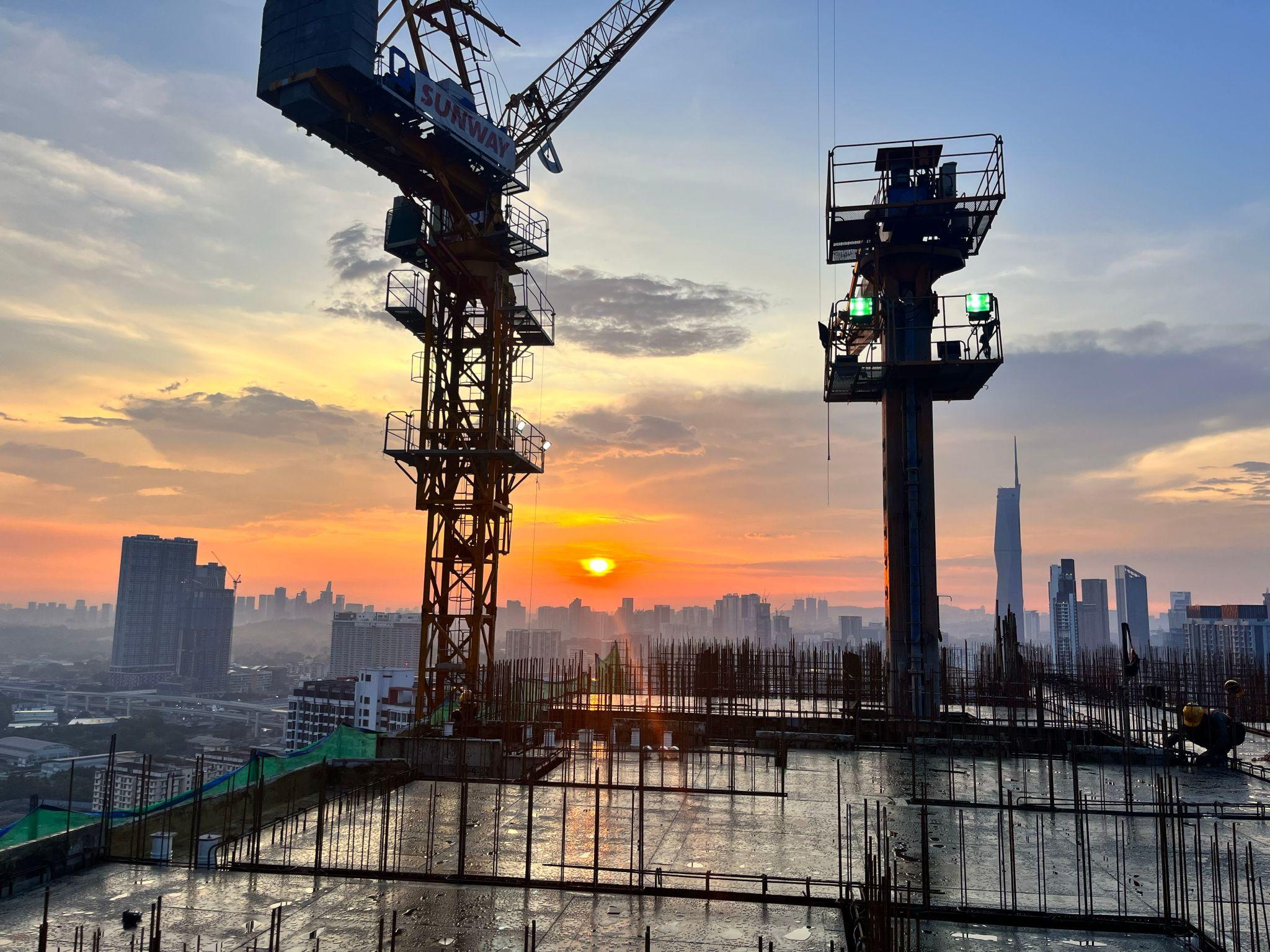 Concrete and structural construction site with cranes at sunset