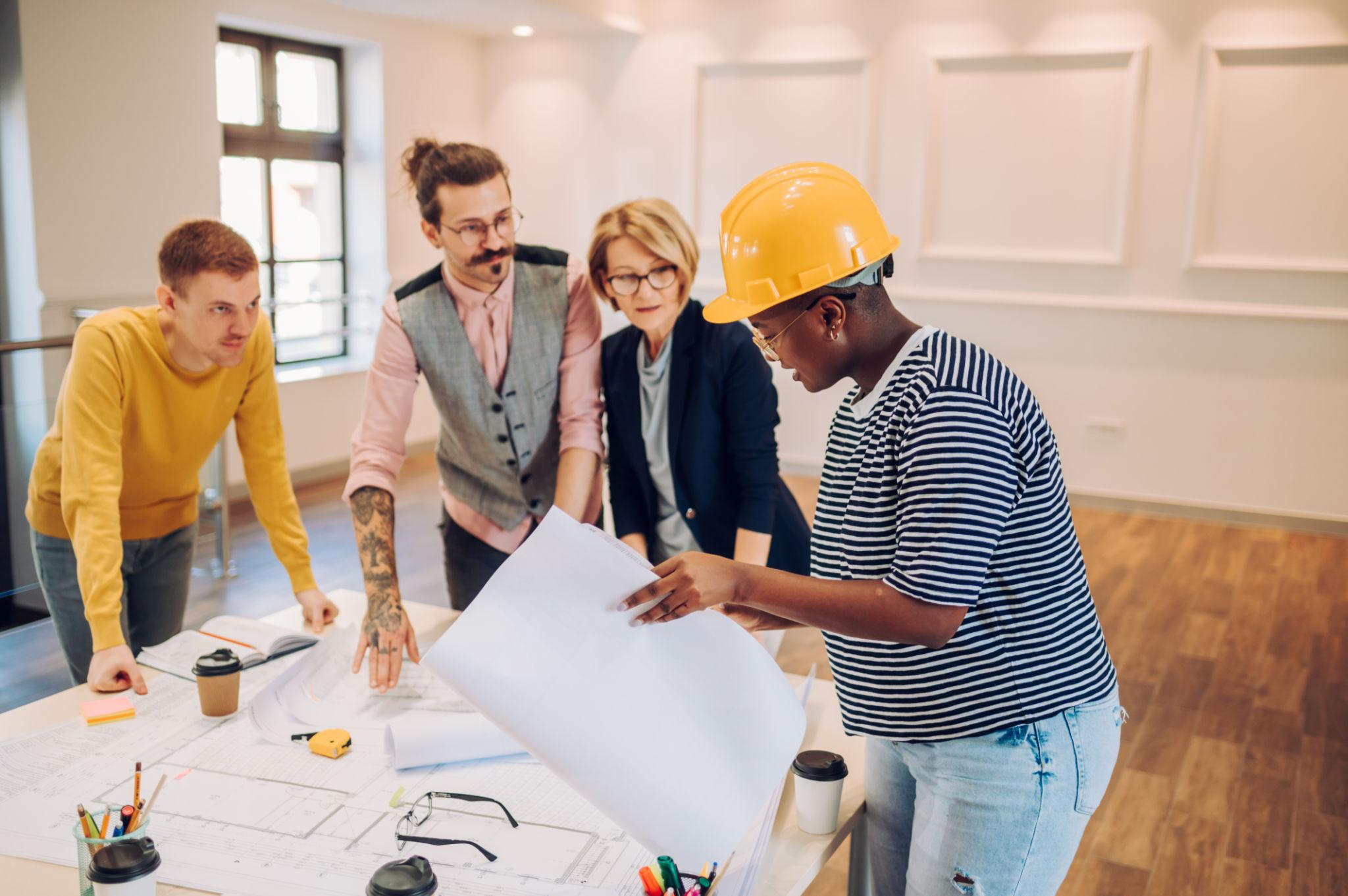 Construction professional reviewing plans with clients in a finished interior