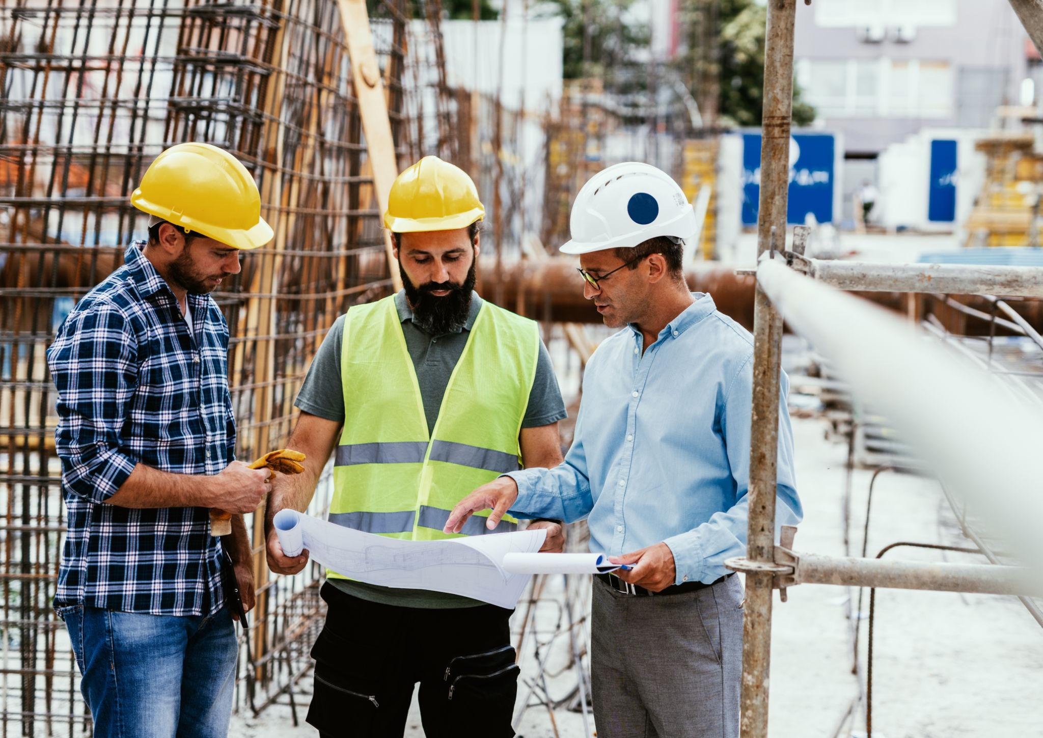 Experienced construction team reviewing project plans on site