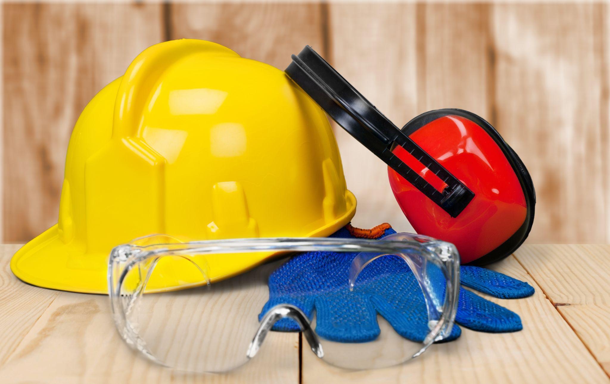 Construction safety equipment including hard hat, ear protection, gloves, and safety glasses